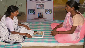 Home Based Child Care: a health worker counselling a mother with a picture booklet